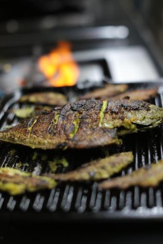 a group of food cooking on a grill at The Postcard Cuelim, Goa in Cansaulim