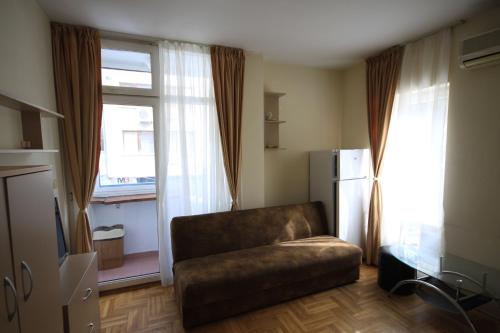 a living room with a couch in front of a window at Studios near to Burgas Free University in Burgas City