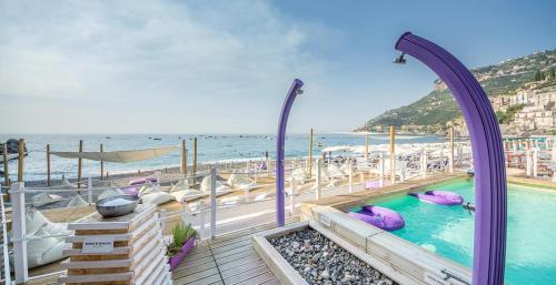 a swimming pool on a deck next to the beach at Eden Holiday in Minori