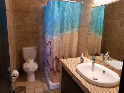 ein Badezimmer mit Waschbecken und Toilette in der Unterkunft Corfu Glyfada Menigos Resort 73 in Glyfada