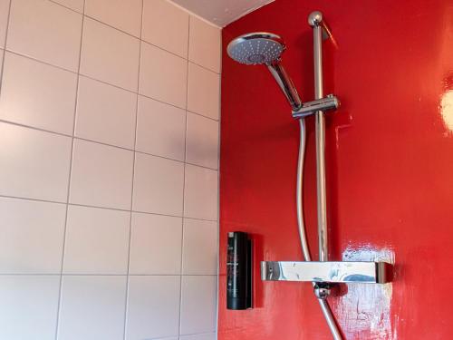 a shower in a bathroom with a red wall at SWEETS - Kortjewantsbrug in Amsterdam