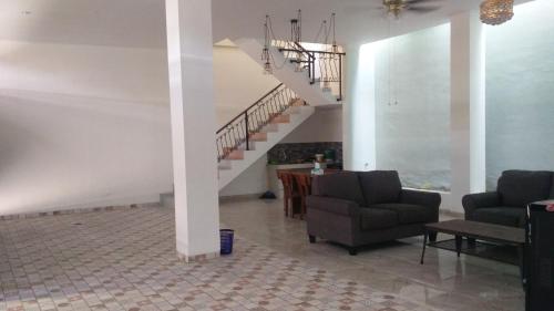 a living room with two chairs and a staircase at ZG Homestay Solo in Sumber