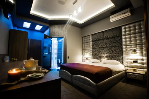 a bedroom with a bed and a table with a candle at Hotel Aqua in Târgu Jiu