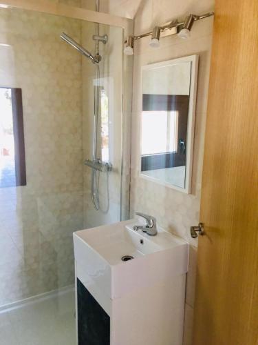 a bathroom with a white sink and a shower at CASA RIBAS in Santa Eularia des Riu