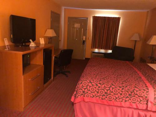 a hotel room with a bed and a flat screen tv at Days Inn by Wyndham Franklin in Franklin