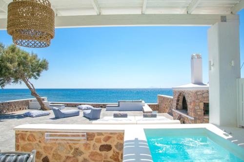 a patio with a swimming pool and the ocean at Aegean Melody Suites & Villas in Vlychada