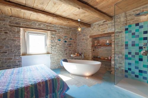 ein Bad mit einer Badewanne, einem Bett und einer Glasdusche in der Unterkunft La Locanda Della Campanara in Santa Sofia