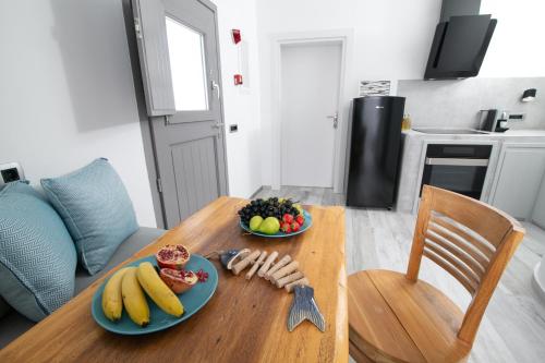a wooden table with two plates of fruit on it at Aegean Melody Suites & Villas in Vlychada