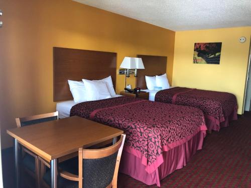 a hotel room with two beds and a table at Days Inn by Wyndham Franklin in Franklin