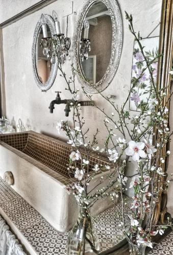 ein Badezimmer mit einem Waschbecken und einer Vase mit Blumen in der Unterkunft B&B CUCUTÍ in Ziano Piacentino