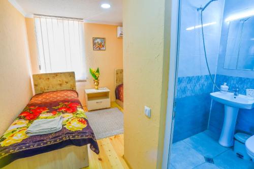 a bathroom with a bed and a sink and a shower at Hotel 9th Sky in Kutaisi