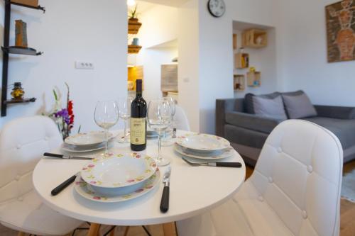 una mesa de comedor blanca con copas y una botella de vino en Your ONE and ONLY, en Belgrado
