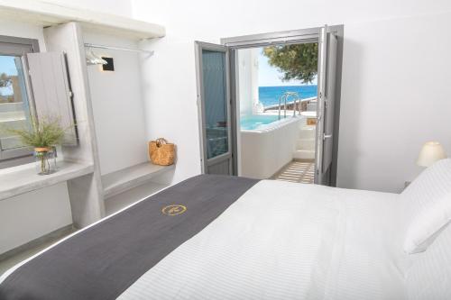 a bedroom with a bed and a view of the ocean at Aegean Melody Suites & Villas in Vlychada