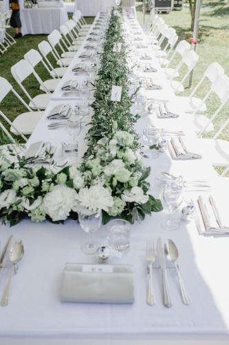 a long white table with white flowers and silverware at Tobacco Village in Meinong