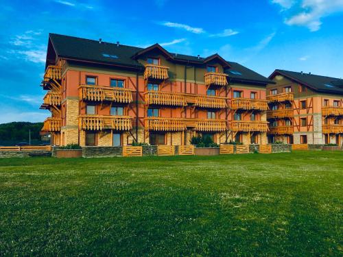 美國魯穆尼卡的住宿－Apartman I104 Velka Lomnica Golf Resort，一座大型公寓楼,前面有一个绿色的场地