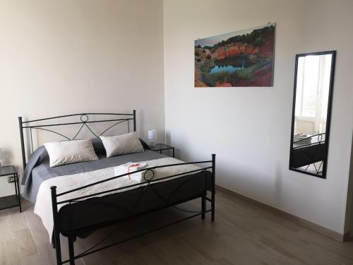 a bedroom with a bed and a mirror on the wall at Casa Midori in Lecce
