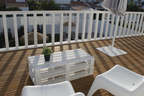 a white table and two white chairs on a deck at Recantus Comporta in Comporta