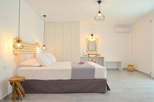 a bedroom with a large white bed and a mirror at La casa de Verde in Péran Triovasálos