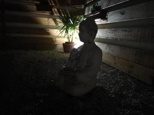 a statue of a buddha sitting on the ground at Quinta Sao Martinho in Reguengo Grande