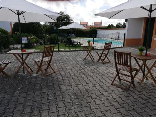 a group of tables and chairs with umbrellas at Quinta Sao Martinho in Reguengo Grande