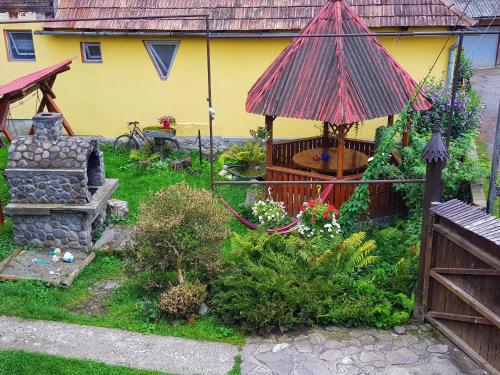 a garden with a gazebo and a house at Eszter Panzió in Praid