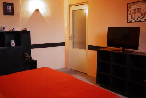 a bedroom with a bed and a television on a dresser at Penzion Tilia in Levice