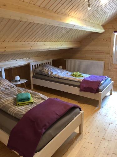 a attic room with two beds in a cabin at Ferienhaus am Harkebrügger See in Barßel