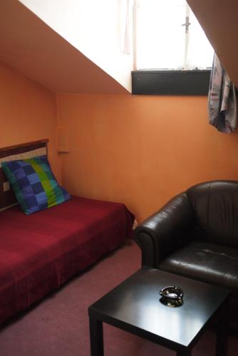 a room with a bed and a couch and a table at Penzion Tilia in Levice
