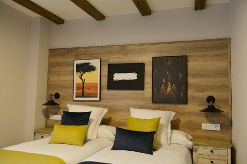 a bedroom with two beds and a wooden headboard at La casita de El Cuervo in El Cuervo