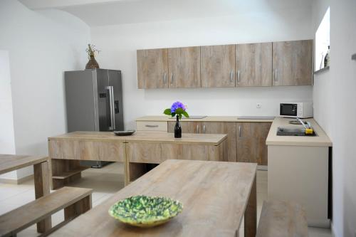 a kitchen with a wooden table and a refrigerator at Hostel Ormož in Ormoz
