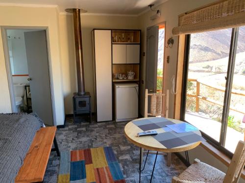 a living room with a table and a stove at Cabañas Miraelqui in Pisco Elqui