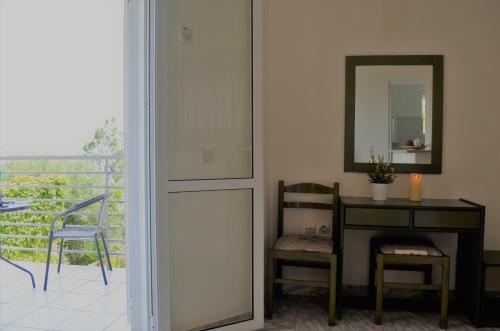 a room with a table and a mirror and a chair at Odyseas Studios in Lourdhata