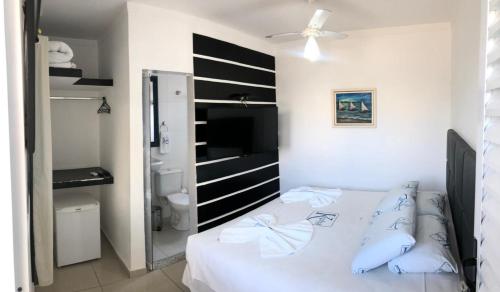 a bedroom with a white bed with blue pillows at Pousada Kepha in Guarujá