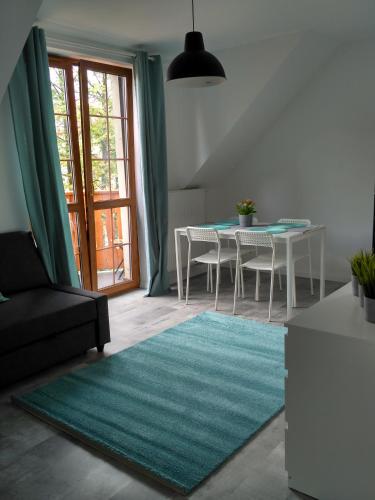 un soggiorno con tavolo e tappeto verde di Apartament Kopa a Karpacz