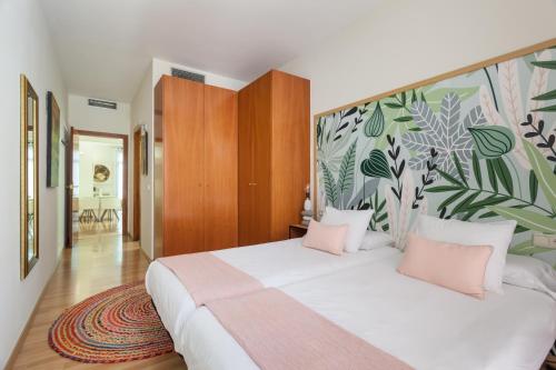 a bedroom with a large white bed with pink pillows at Art House Sagrada Familia in Barcelona