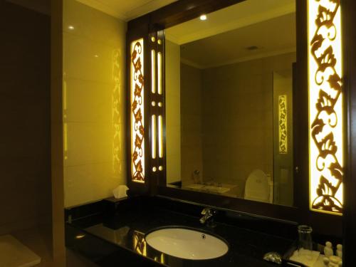 a bathroom with a sink and a large mirror at Ari Putri Hotel in Sanur