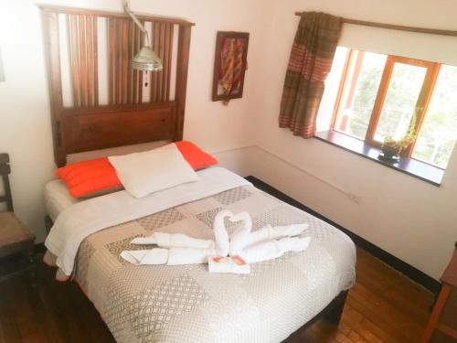 a bedroom with two swans towels on a bed at Casa Patacalle in Ollantaytambo