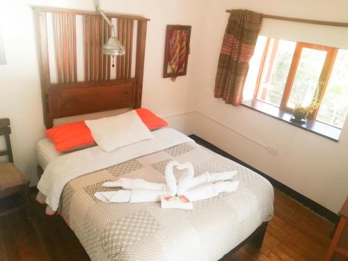a bedroom with a bed with two white towels on it at Casa Patacalle in Ollantaytambo