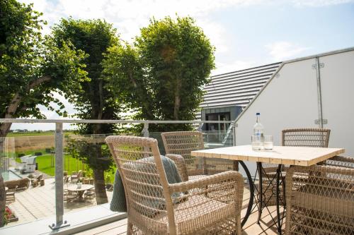 a patio with a table and chairs on a balcony at Hotel Hof Galerie in Morsum