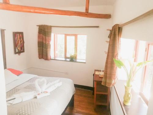 sypialnia z łóżkiem i oknem w obiekcie Casa Patacalle w mieście Ollantaytambo