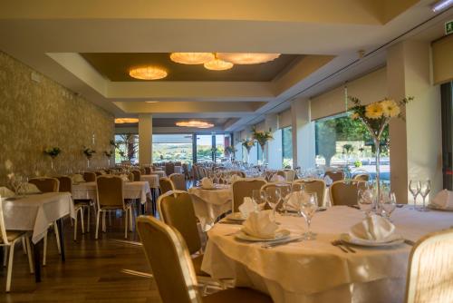 a dining room with white tables and chairs at Terrace Serra Hotel in Covilhã