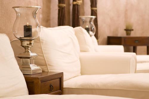 a row of white couches with a candle on a table at SATAMA Sauna Resort & SPA in Wendisch Rietz