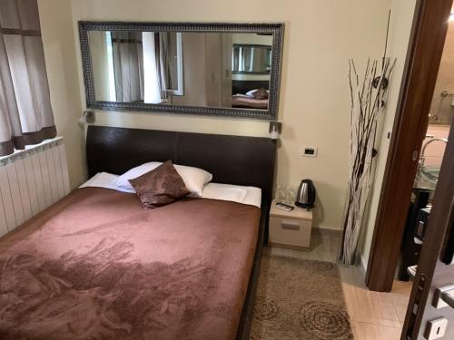 a small bedroom with a bed and a mirror at Enter Rooms in Zagreb