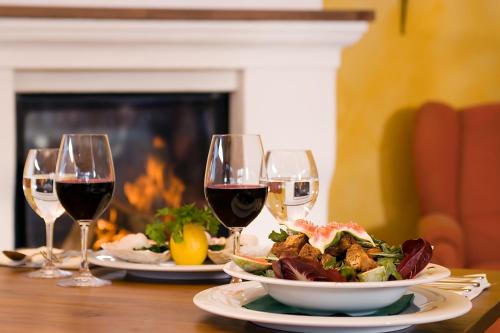 a table with two glasses of wine and a plate of food at SATAMA Sauna Resort & SPA in Wendisch Rietz