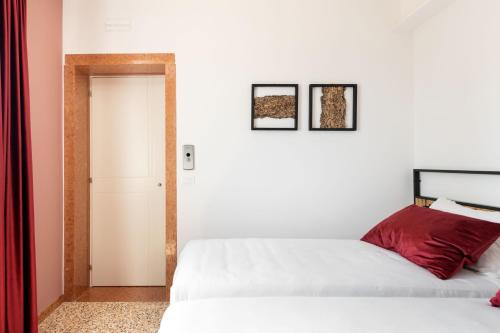 two beds in a white room with a doorway at Sea Tower Torre Telemetrica Lido di Venezia in Venice-Lido