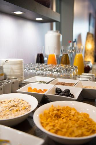 a table with bowls of food on a counter at Hotel Hof Galerie in Morsum