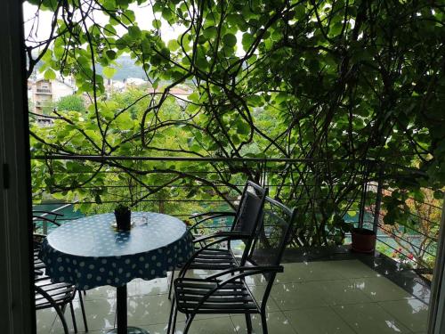 a table and chairs on a patio with a view of a tree at Elite Guest House in Mostar