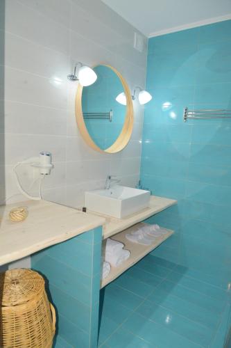 a blue bathroom with a sink and a mirror at La casa de Verde in Péran Triovasálos