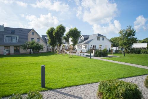 a yard with a house and a grassy field at Hotel Hof Galerie in Morsum