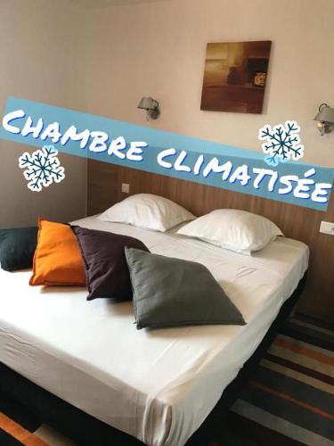 - un grand lit avec des oreillers dans l'établissement Kyriad Direct Agen, à Castelculier